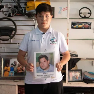 Un familiar de Lupita y Josué sostiene su ficha de búsqueda