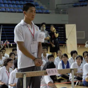 学生们在观摩模拟法庭庭审现场，学生扮演的士兵正在受审，他们被控犯有违反国际人道法的罪行。