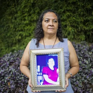 Un familiar de doña Cony sostienes su retrato 