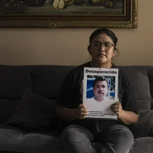 Liz sujeta la ficha de búsqueda de su papá 