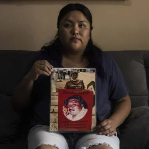 Carmen sujeta la ficha de búsqueda de su papá 