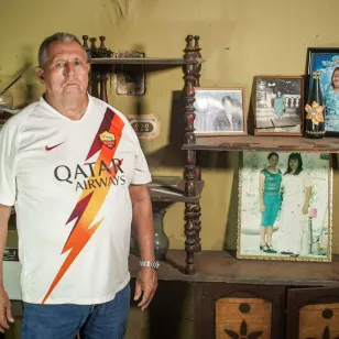 Don Héctor Aristondo junto a fotografías de su hija y esposa 