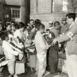Red Cross workers providing clothing to war refugees (2 November 1950)