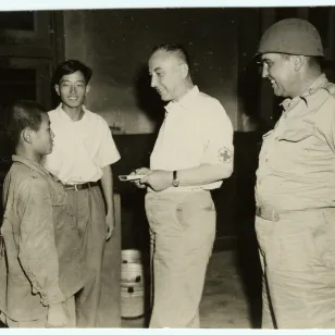 Busan, Camp EUSAK No. 1. An ICRC delegate Frédéric Bieri in conversation with a young prisoner of war (29 July 1950)