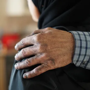 Abu's hand on Umm's shoulder