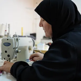 Ratiba sitting at her sewing machine