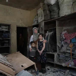 Una madre y dos hijos en un hogar destruido en Líbano.