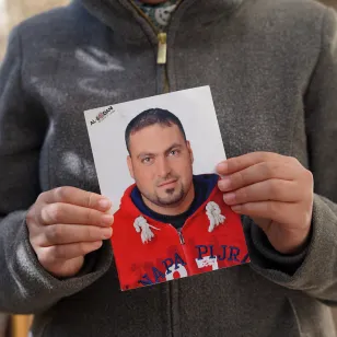 A girl holds her father's picture