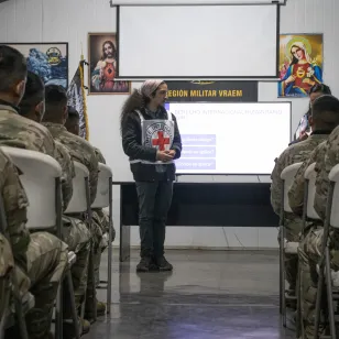 Un trabajador del CICR hablando a militares en un aula.