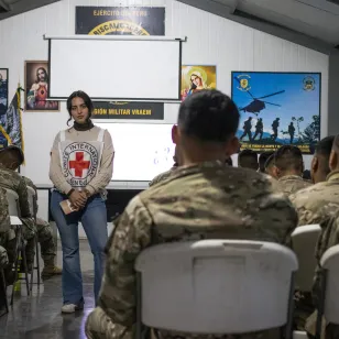 Una trabajadora del CICR escucha atentamente a un militar.