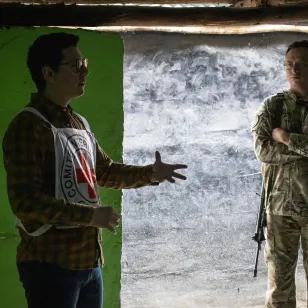 Un trabajador del CICR da una charla mientras un militar lo escucha.