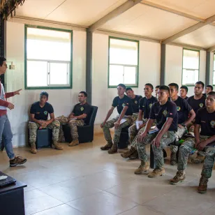 Un trabajador del CICR brinda una charla a personal militar en un aula.