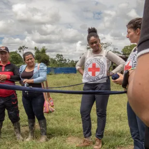 arias personas forman un círculo mientras sostienen una red en el centro. Al fondo, se distingue a una persona del CICR, mientras otras observa atentamente la dinámica.