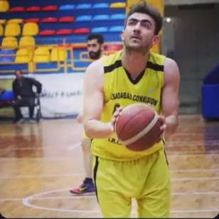 Yaser Zivari in a yellow basketball uniform prepares to take a free throw on an indoor court