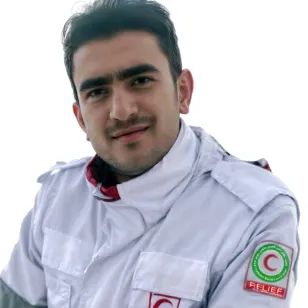 Portrait of Yaser Zivari, a Red Crescent staff member, wearing a white uniform with the Red Crescent emblem on the sleeve