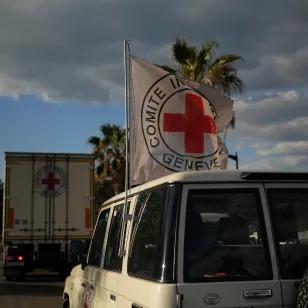 Un vehículo del CICR con una bandera de la Cruz Roja sigue a un camión que transporta suministros humanitarios por una carretera costera en el Líbano, durante operaciones en medio de la intensificación de las hostilidades.