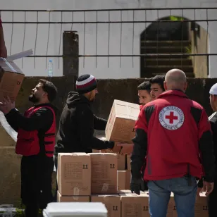 Staff from the International Committee of the Red Cross unloading a truck with aid parcels.