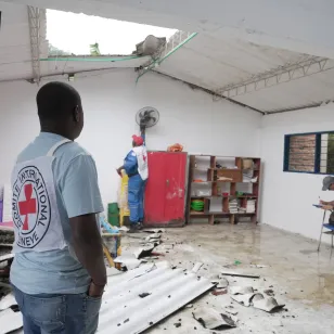 ICRC staff assess damage inside a school in Chocó, Colombia, following an earthquake. Debris is scattered across the floor and part of the roof has collapsed.