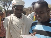 Un padre (izquierda) escucha el mensaje que su hijo detenido le ha enviado a través del CICR, Teletele, Borena, región de Oromia
