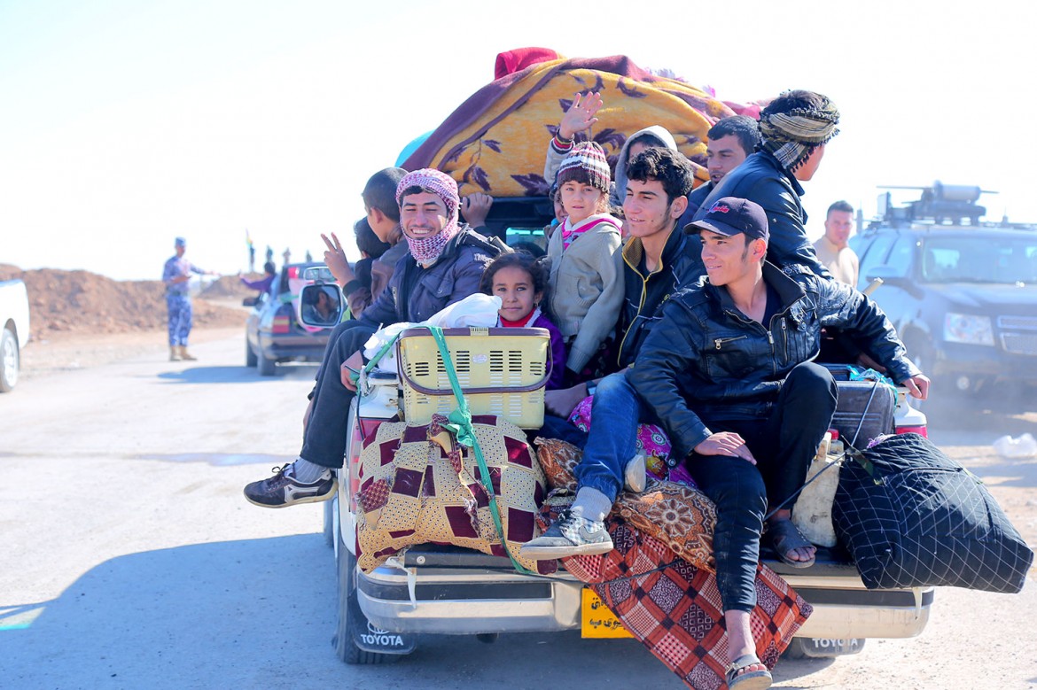 Sur la route qui part de Mossoul en direction de l'est, des hommes, des femmes et des enfants fuient la villes et les combats. Ils traversent le village kurde de Gogjali, situé sur le chemin en direction du camp de déplacés d'Al Khazar.
