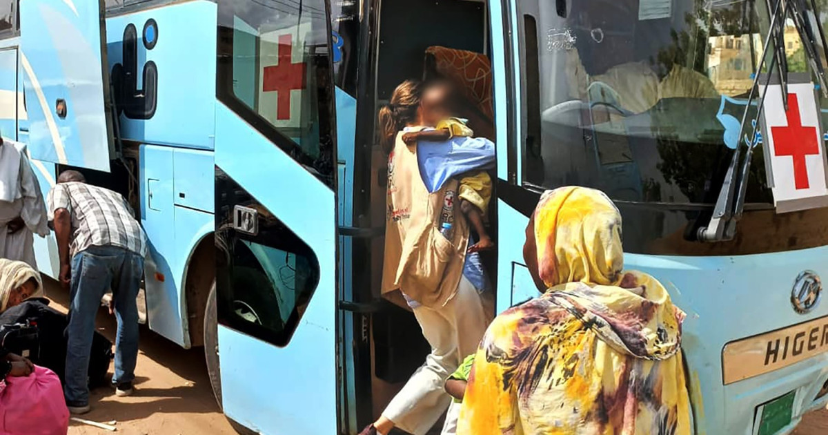 an_icrc_worker_carries_children_during_t