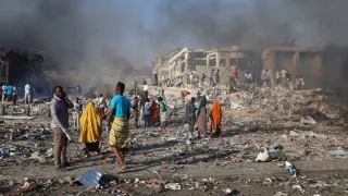 Civilians prepare to carry dead bodies of unidentified persons after an explosion in Mogadishu, Somalia.