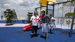 At an ICRC rehabilitation center in Guanajato, Mexico, a volunteer from the Mexican Red Cross assists two beneficiaries.