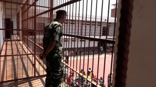Un homme de dos, en tenue, dans une prison à Madagascar.