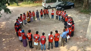 ICRC staff standing facing each other in a circle with picture taken from above