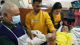 A medical professional and volunteers treat a child with clubfoot, through Ponseti method, at the CURE clinic in St Stephen’s Hospital, New Delhi.