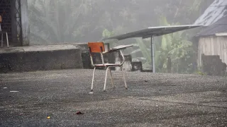 Una silla en medio de un patio, como abandonada, y atrás se ve un contexto de zona rural