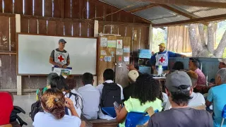 Una persona del CICR está realizando una charla sobre artefactos explosivos en una comunidad.