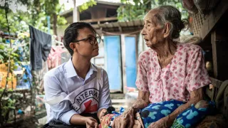 An ICRC worker with a woman in Myanmar
