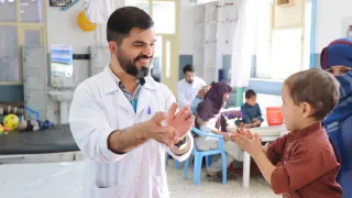 An ICRC staff playing with a child suffering from Cerebral Palsy at the ICRC's physical rehabilitation centre in Kabul