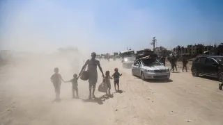 A father with his 4 children walking in an area full of sand