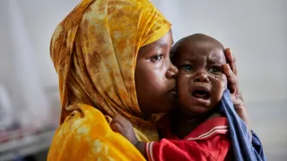 Marwo Abdikarim consoles her 11-month-old, Ahmed Hussein Mohamed, at the stabilization centre in Kismayo.