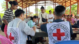 Two ICRC staff assisting people in Myanmar