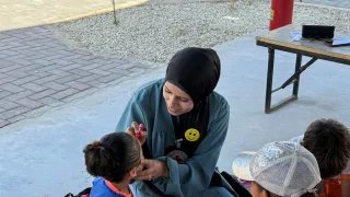 Dr Sally taking children through recreational activities to support mental health at the Gaza Field Hospital.jpg