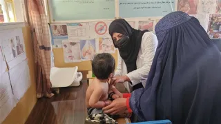 An Afghan Red Crescent Society (ARCS) healthcare worker examining a patient at an ARCS's clinic in Kabul