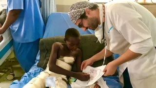 Egyptian anesthesiologist Dr. Aktham Al-Farnawani encourages a child to color after he was injured in an explosion in Maiduguri, Nigeria.