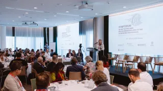 Group of search practioners and experts from various sectors in a conference room with a speaker on the stage