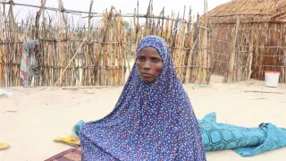 Une femme du projet mamans lumière à Bagasola assise sur une natte