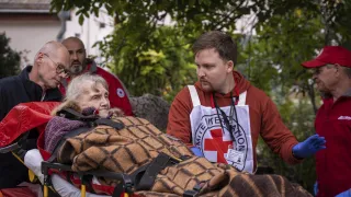 Mykolaiv. An ICRC staff member is talking to an old lady while she is being transferred to a new specialized facility.