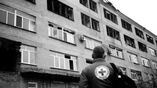 An ICRC staff member observes the wreckage of a damaged hospital in Petropavlivka, Ukraine. 