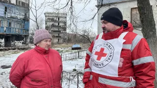 ICRC staff talks to Galina in in Krasnohorivka where ICRC distributed aid to the affected population.