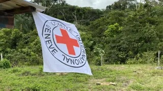 En medio de una zona rural de Colombia, se encuentra colgada una bandera del CICR.