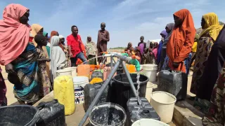 Community water point with community members fetching water