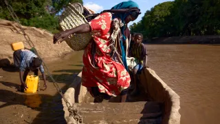 A woman navigates her seat in a boat in Somalia.