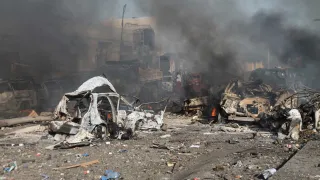 A street in ruins, littered with destroyed vehicles.