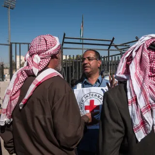 In eastern Jordan, Mafraq, an ICRC employee tells Syrian refugees about the services available to re-establish contact with relatives.